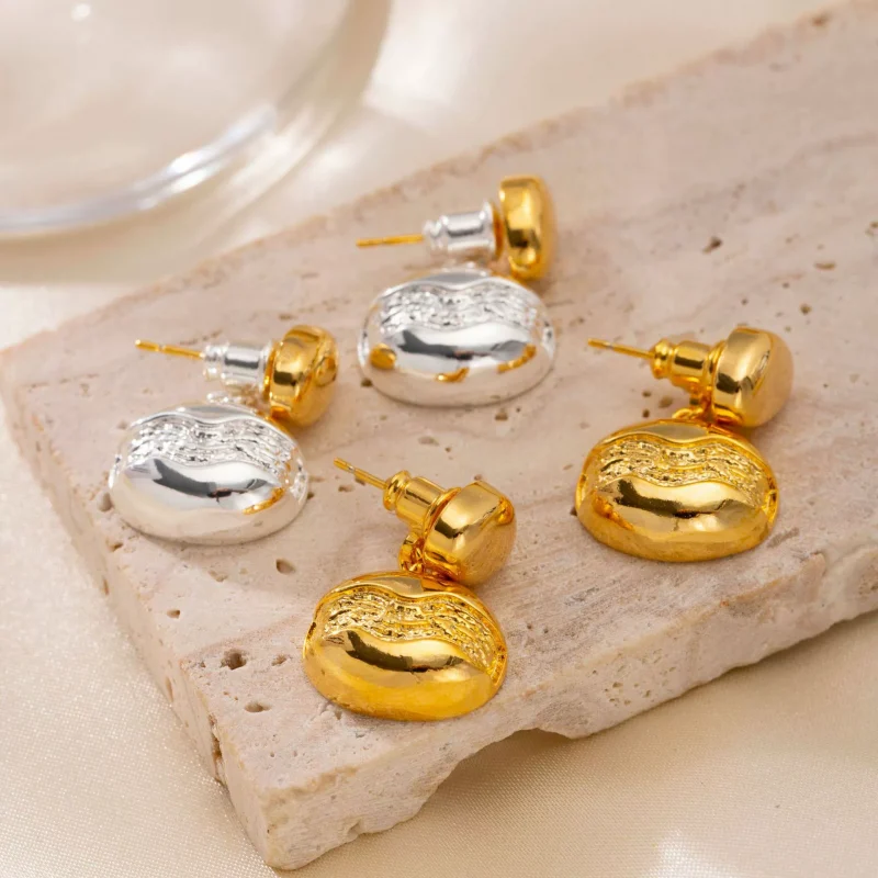 Close-up of brass gold-plated stud earrings showcasing elegant minimalist design.