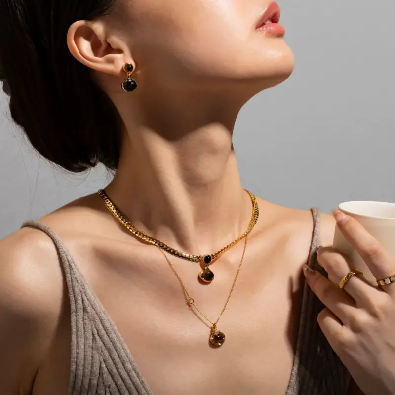 FY’s gold tiger eye oval pendant on a snake chain, styled with a linen dress for boho-chic everyday elegance.