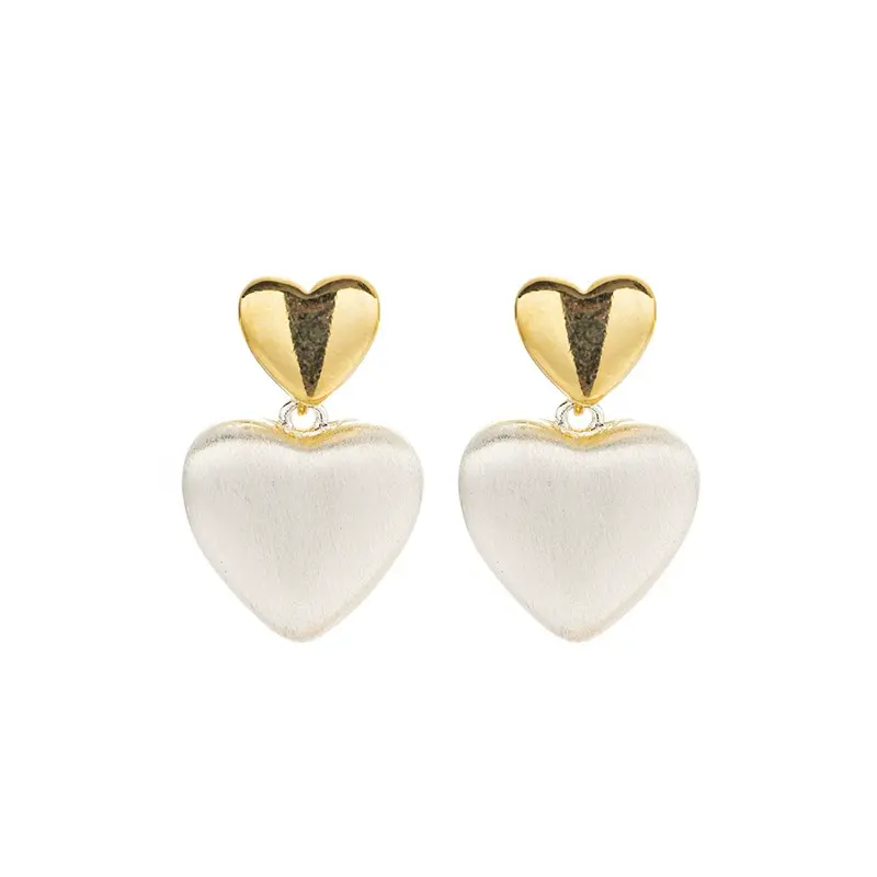 FY’s vintage heart stud earrings with textured gold finish, styled with a denim jacket for casual-chic outfits.