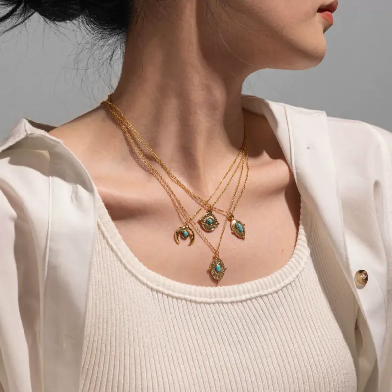 FY’s gold oval bead necklace with intricate vintage texture, styled with a black evening gown for royal-inspired elegance.