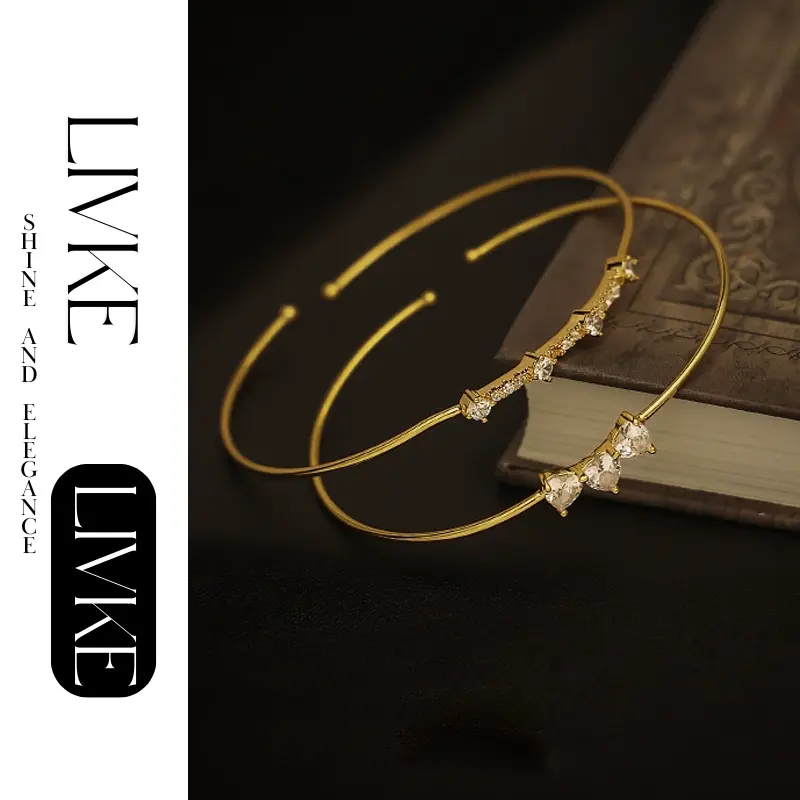 FY’s gold open cuff bracelet with cubic zirconia, styled with a white shirt and watch for modern minimalist elegance.