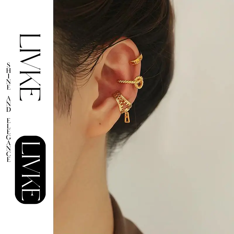 FY’s gold openwork ear cuff styled on a helix, paired with minimalist hoops for edgy everyday elegance.