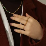 FY’s 18K PVD gold minimalist ring stacked with raw-edge bands for modern gender-neutral style.