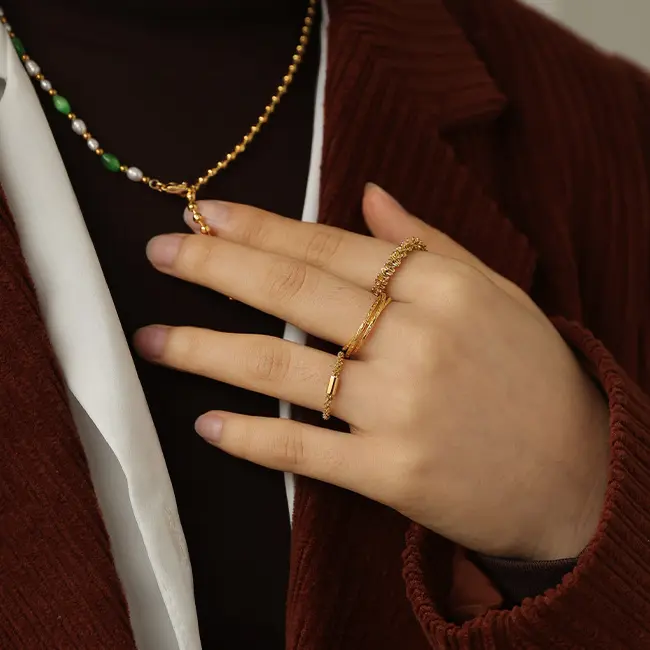 FY’s 18K PVD gold minimalist ring stacked with raw-edge bands for modern gender-neutral style.