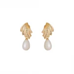 FY’s gold vintage pearl drop earrings with zirconia accents, styled with a black dress for Parisian evening elegance.