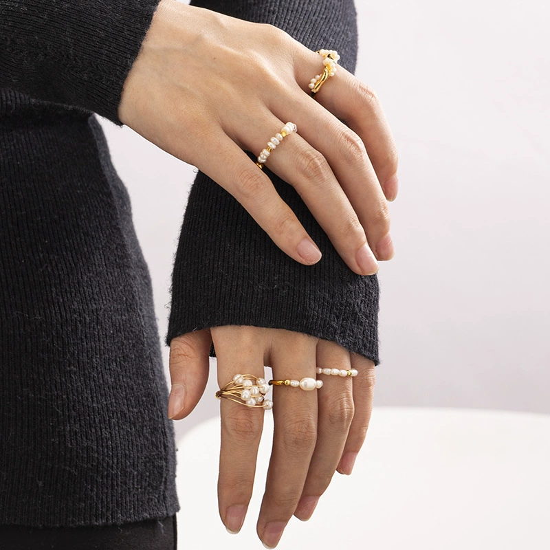 Vintage freshwater pearl set in 18K gold filigree band, styled with lace gloves for bridal elegance.