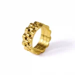 FY’s gold gear ring on a hand with black polish, styled with a leather jacket for urban minimalist edge.