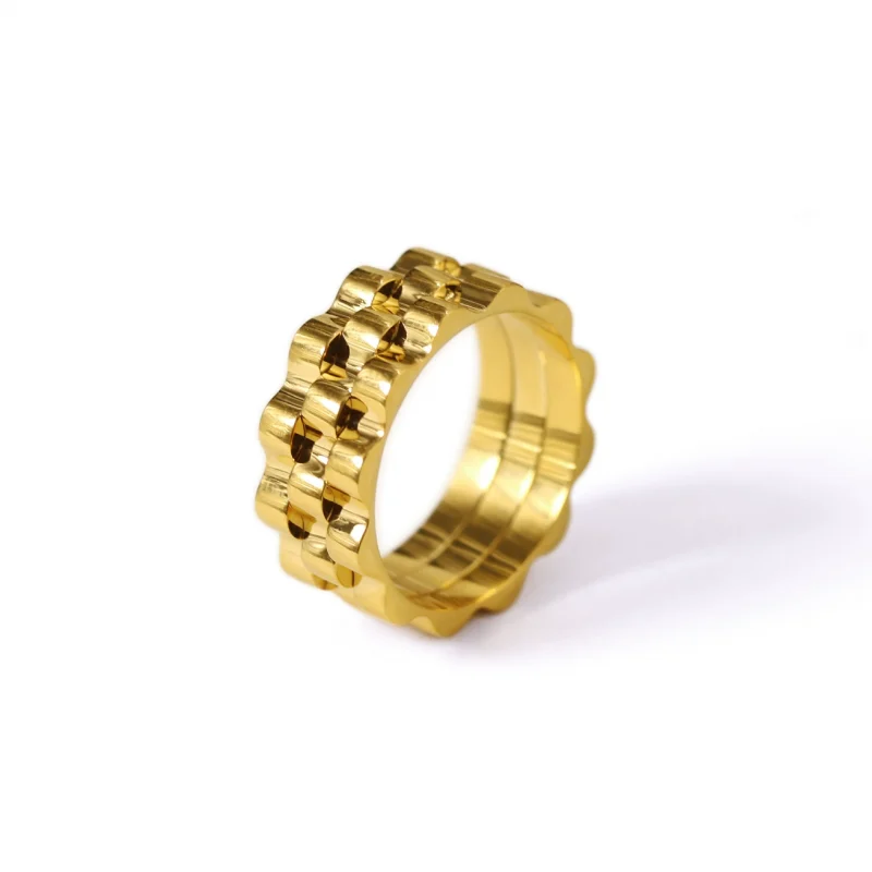 FY’s gold gear ring on a hand with black polish, styled with a leather jacket for urban minimalist edge.