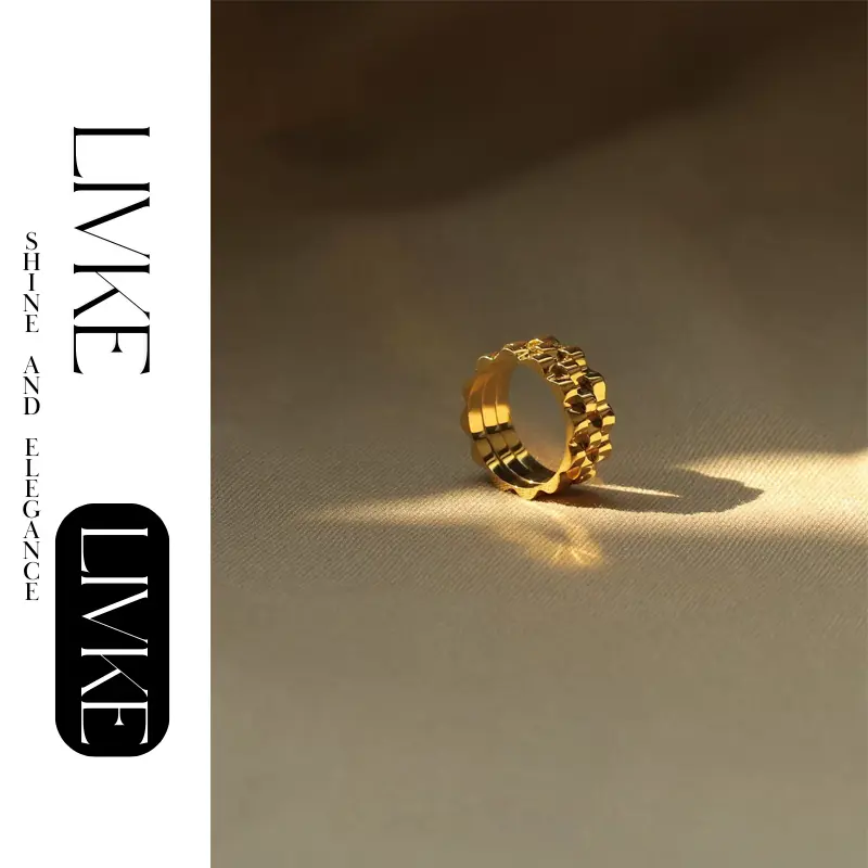 FY’s gold gear ring on a hand with black polish, styled with a leather jacket for urban minimalist edge.