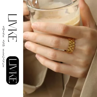 FY’s gold gear ring on a hand with black polish, styled with a leather jacket for urban minimalist edge.
