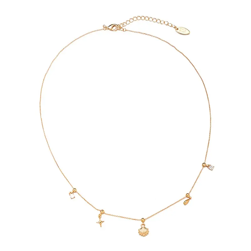 FY’s gold summer wave necklace with shell and zirconia pendant, styled with a straw hat for beachside elegance.