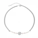 FY’s gold tulip pendant necklace with faux pearl, styled with a trench coat for transitional elegance.