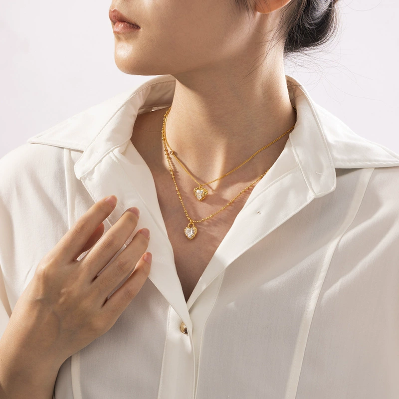 FY’s gold vintage heart necklace with cubic zirconia, layered with a thin chain for minimalist office elegance.