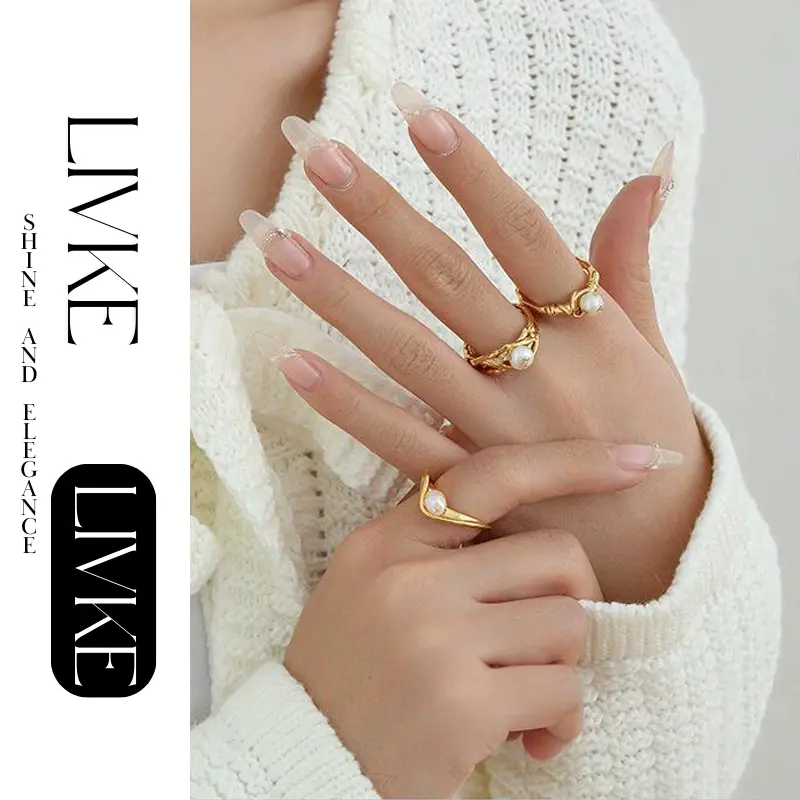 FY’s gold leaf and pearl adjustable ring on a hand with neutral nails, styled with a linen dress for effortless boho elegance.