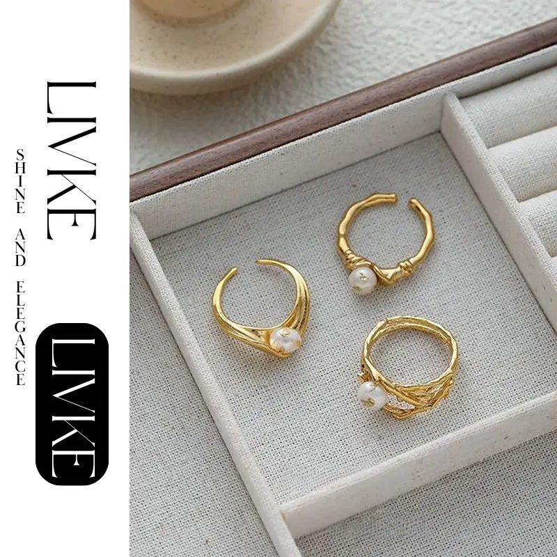 FY’s gold leaf and pearl adjustable ring on a hand with neutral nails, styled with a linen dress for effortless boho elegance.