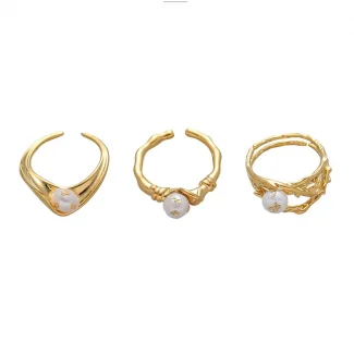 FY’s gold leaf and pearl adjustable ring on a hand with neutral nails, styled with a linen dress for effortless boho elegance.
