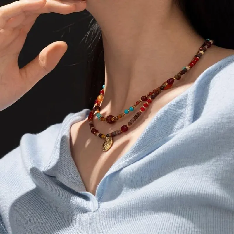 FY surgical steel necklace with red agate and turquoise beads, layered with minimalist chains for boho-chic styling