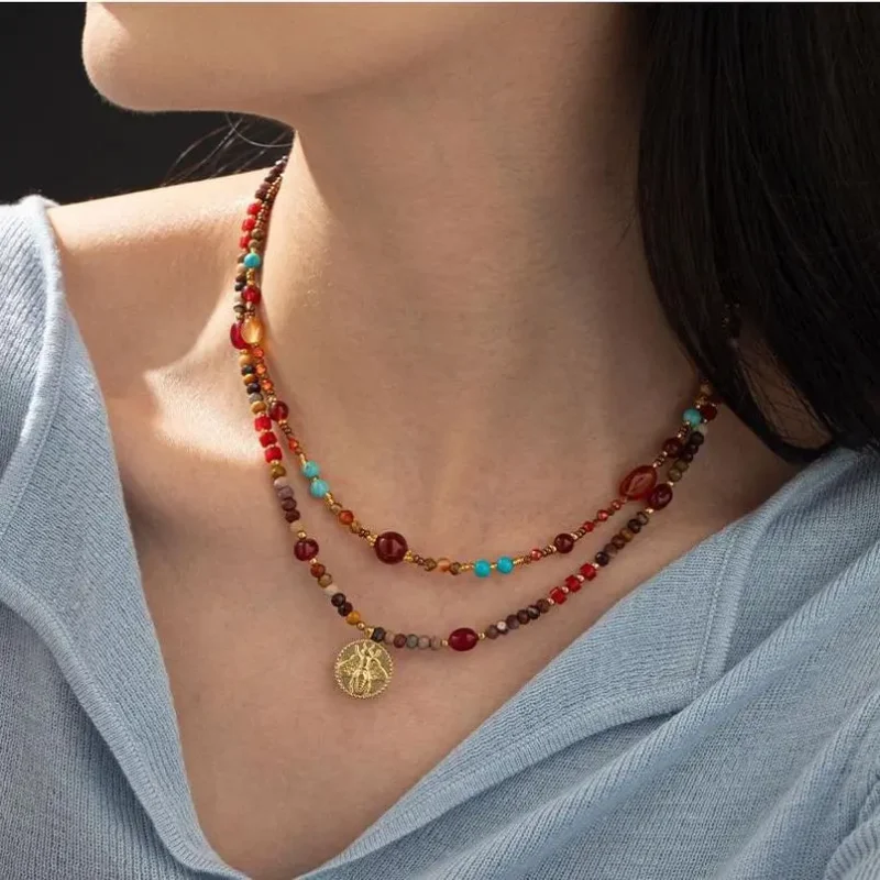 FY surgical steel necklace with red agate and turquoise beads, layered with minimalist chains for boho-chic styling