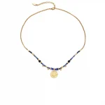 FY’s gold-plated brass necklace featuring a lapis lazuli pendant, styled with a white linen blouse for effortless elegance.