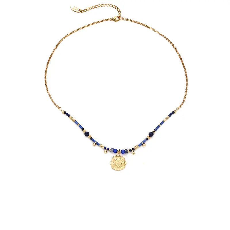 FY’s gold-plated brass necklace featuring a lapis lazuli pendant, styled with a white linen blouse for effortless elegance.