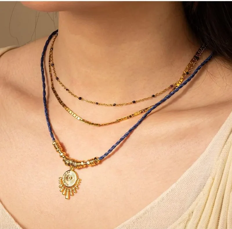 FY’s gold-plated brass necklace featuring a lapis lazuli pendant, styled with a white linen blouse for effortless elegance.